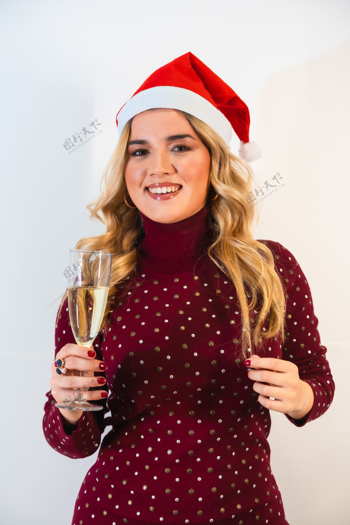 年轻戴着圣诞帽的年轻金发女士在敬酒微笑微笑白种人