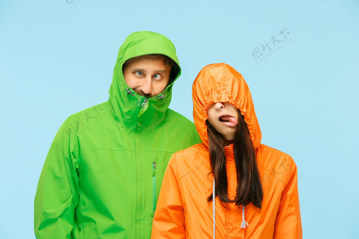 成人这对年轻夫妇穿着蓝色的秋夹克在摄影棚摆姿势天气时尚男性