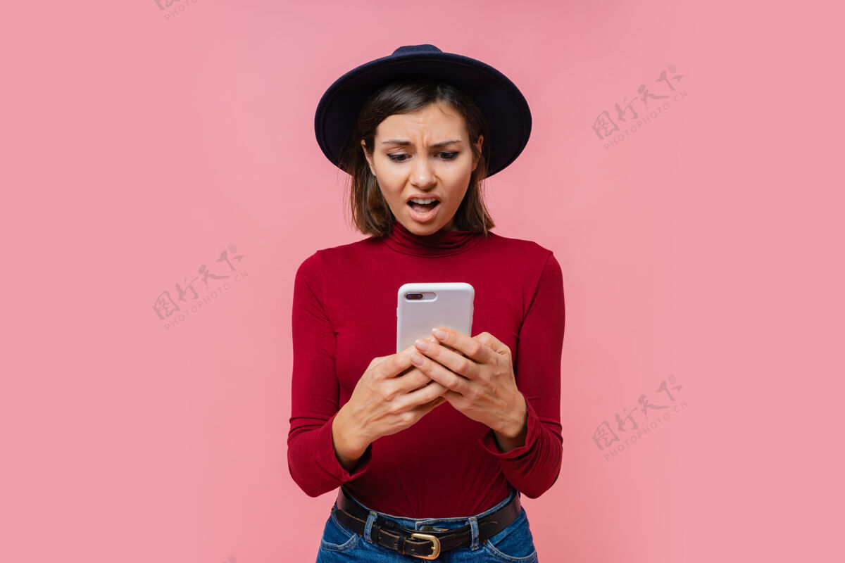 使用困惑的黑发女人手持现代手机 在智能手机设备上输入信息 与世隔绝手机成人严肃