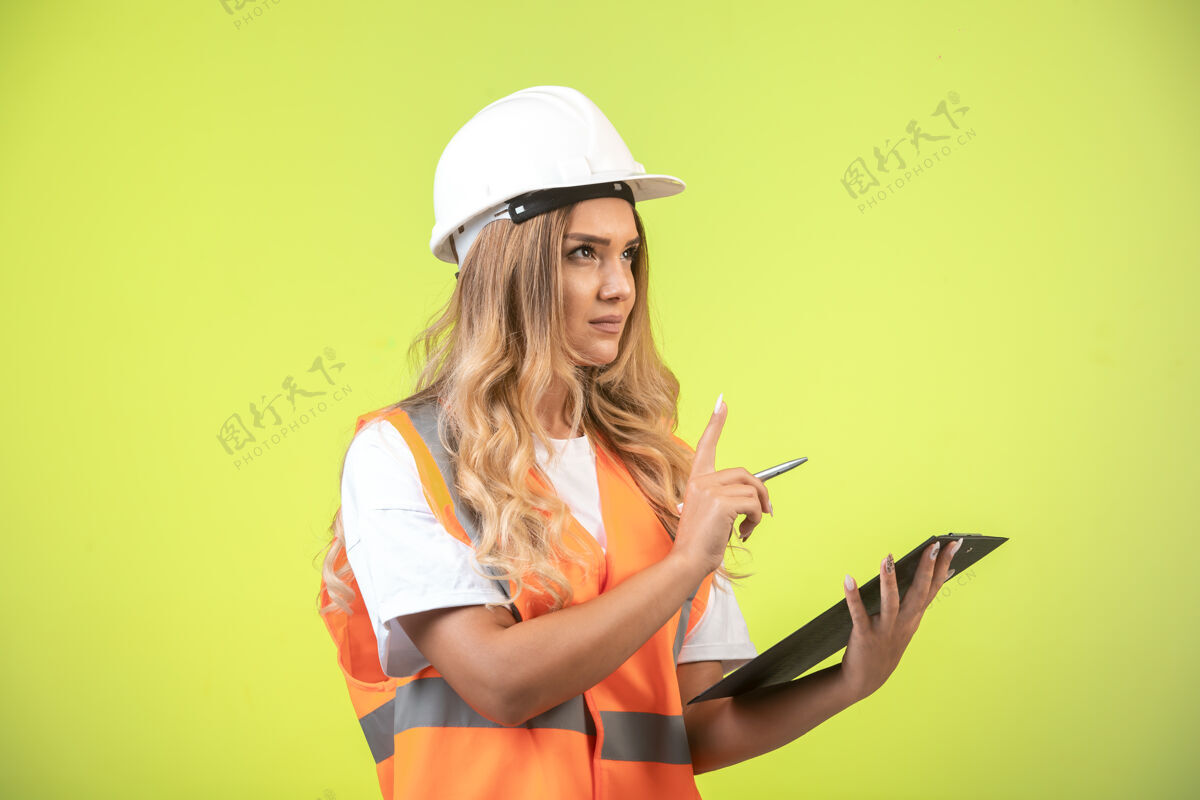 制造商戴着白色头盔和装备的女工程师拿着检查表要求发言工作问题注意