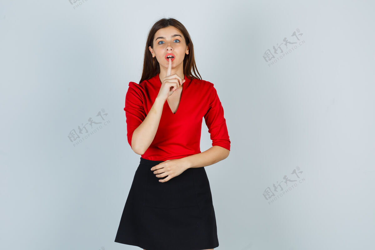 肖像一个穿着红衬衫 黑裙子 表情严肃的年轻女人在沉默成人严重手势