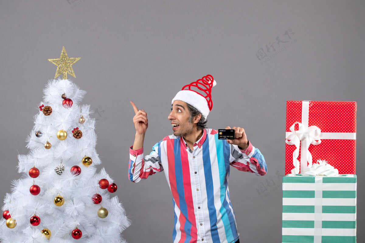 星星前视图快乐的男人信用卡显示圣诞明星站在不同的礼物附近不同快乐人