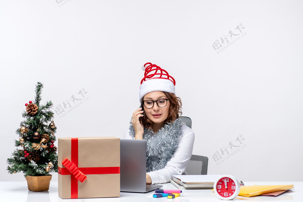 礼物前视图年轻女性在假日工作时使用白色背景的笔记本电脑年轻女性办公室笔记本电脑