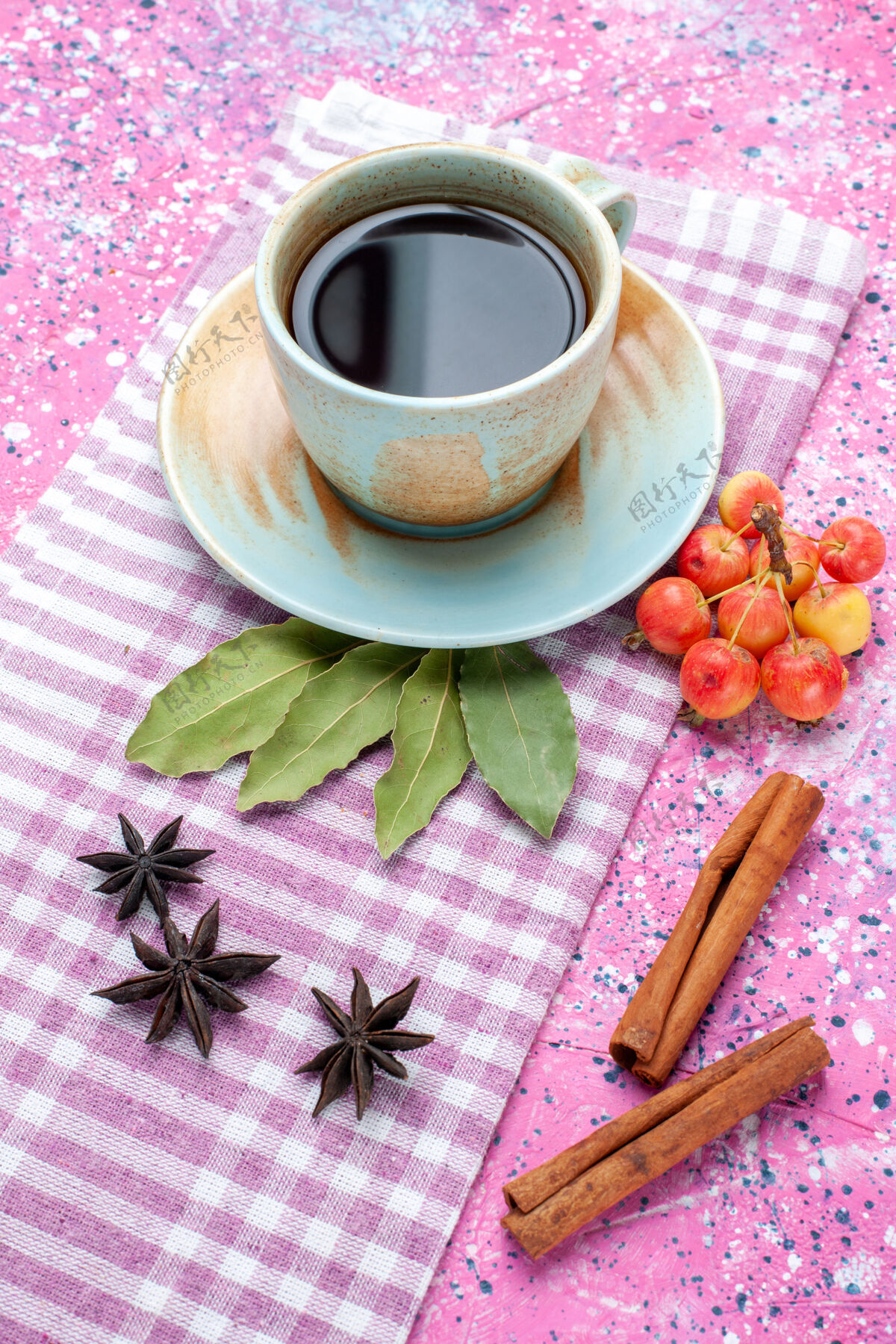 杯子前视一杯茶 用肉桂和樱桃放在粉红色的背上 喝水果色的茶樱桃水果饮料