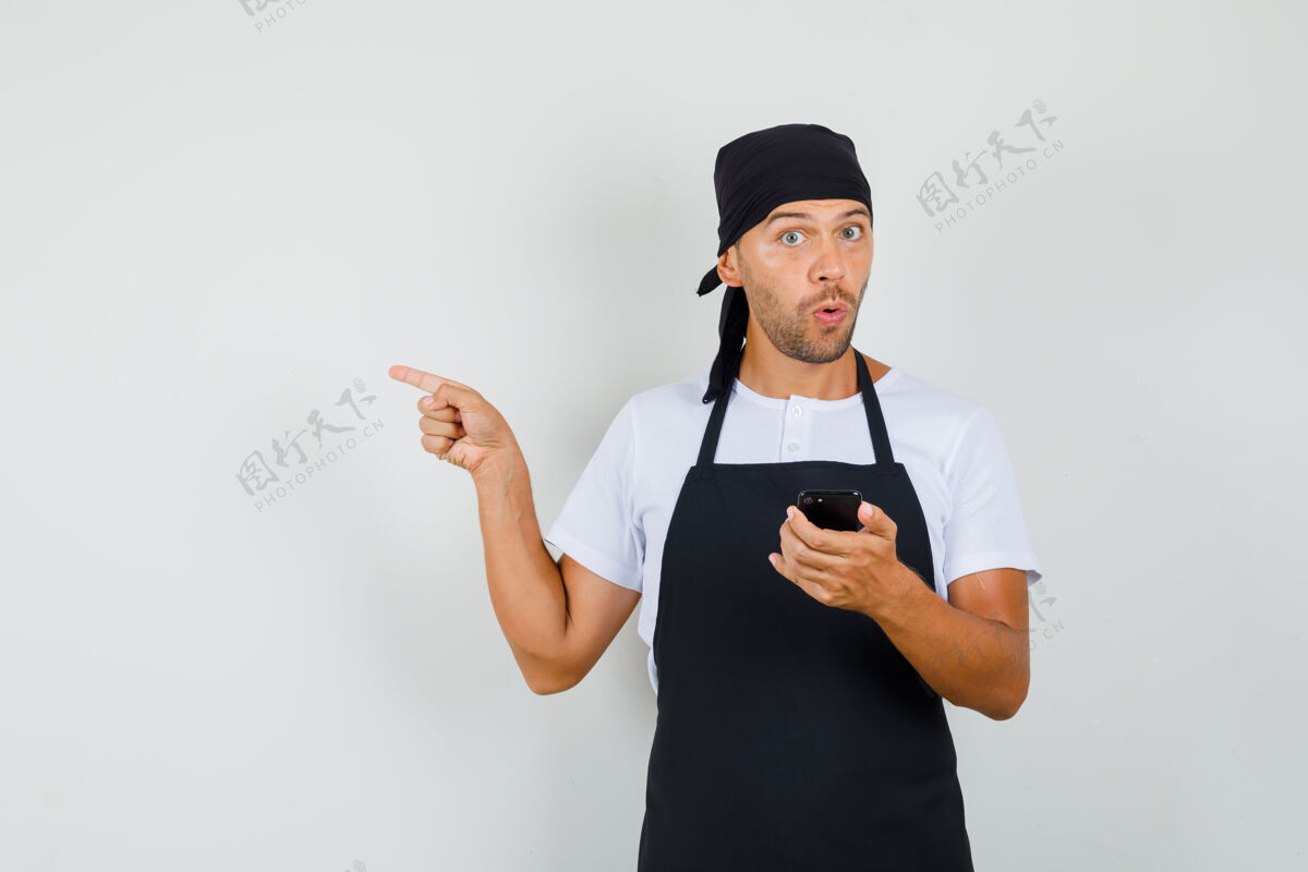 前台面包师穿着t恤 围裙拿着手机厨师成人面包店