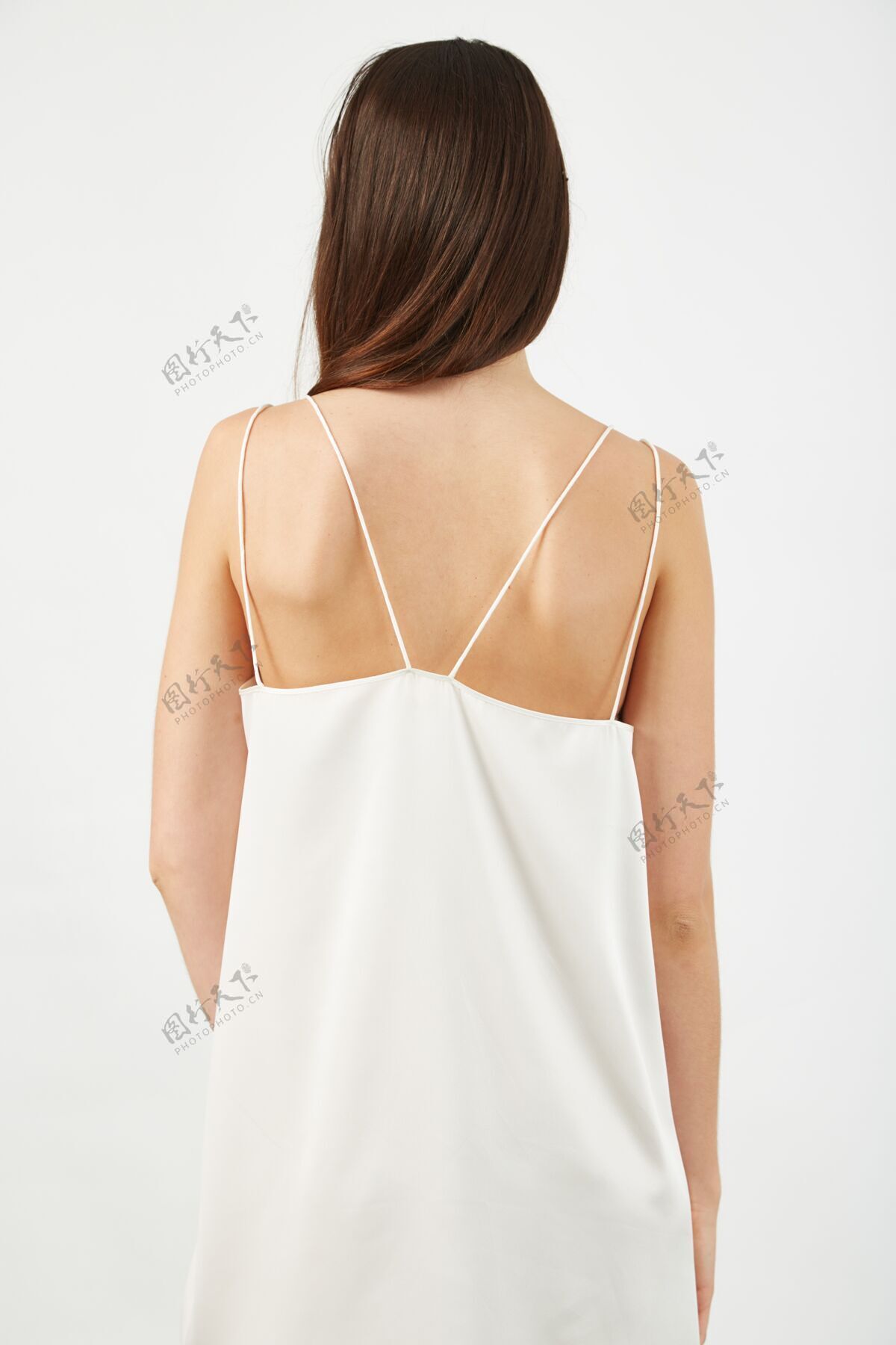 女士摄影棚灯光下一位身穿浅白色连衣裙的女性后背的垂直镜头深色垂直女性