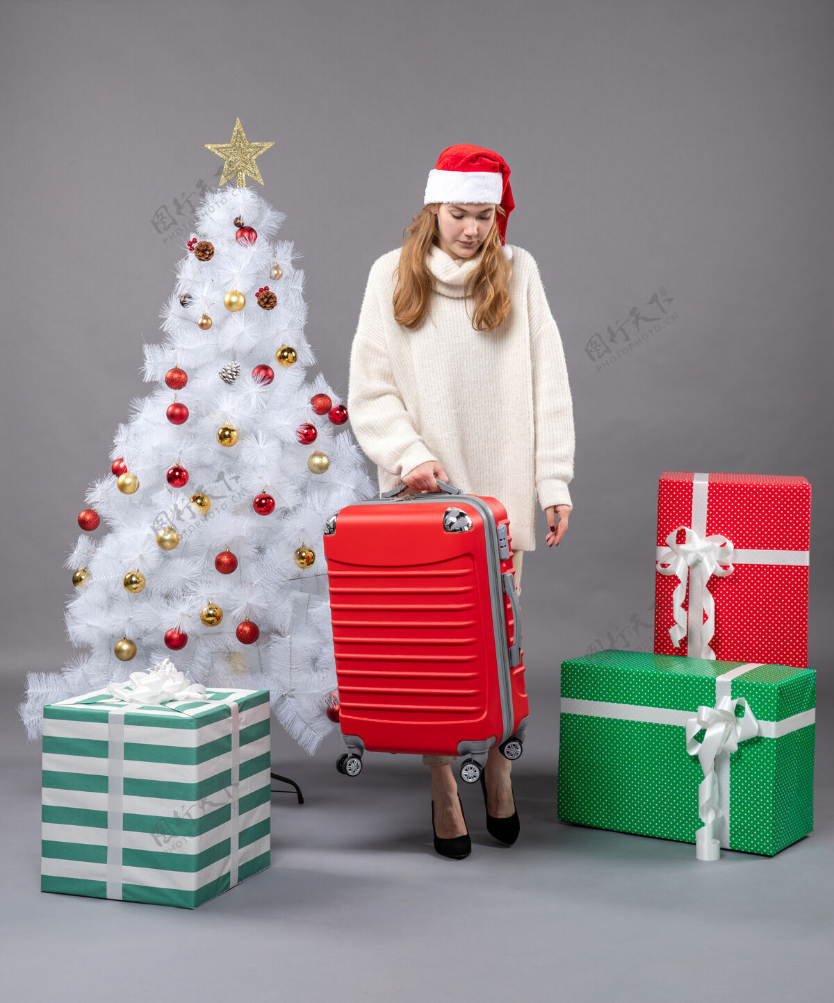 假期前视图：一个戴着圣诞帽拿着旅行包的女孩俯视着行李盒子圣诞老人帽子