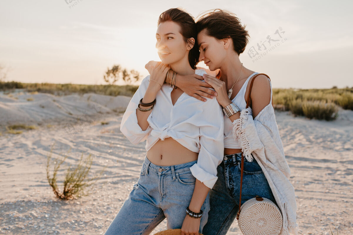 取向可爱的两个年轻女子在日落海滩上嬉戏 男女同性恋的爱情浪漫女性女人Lgbt