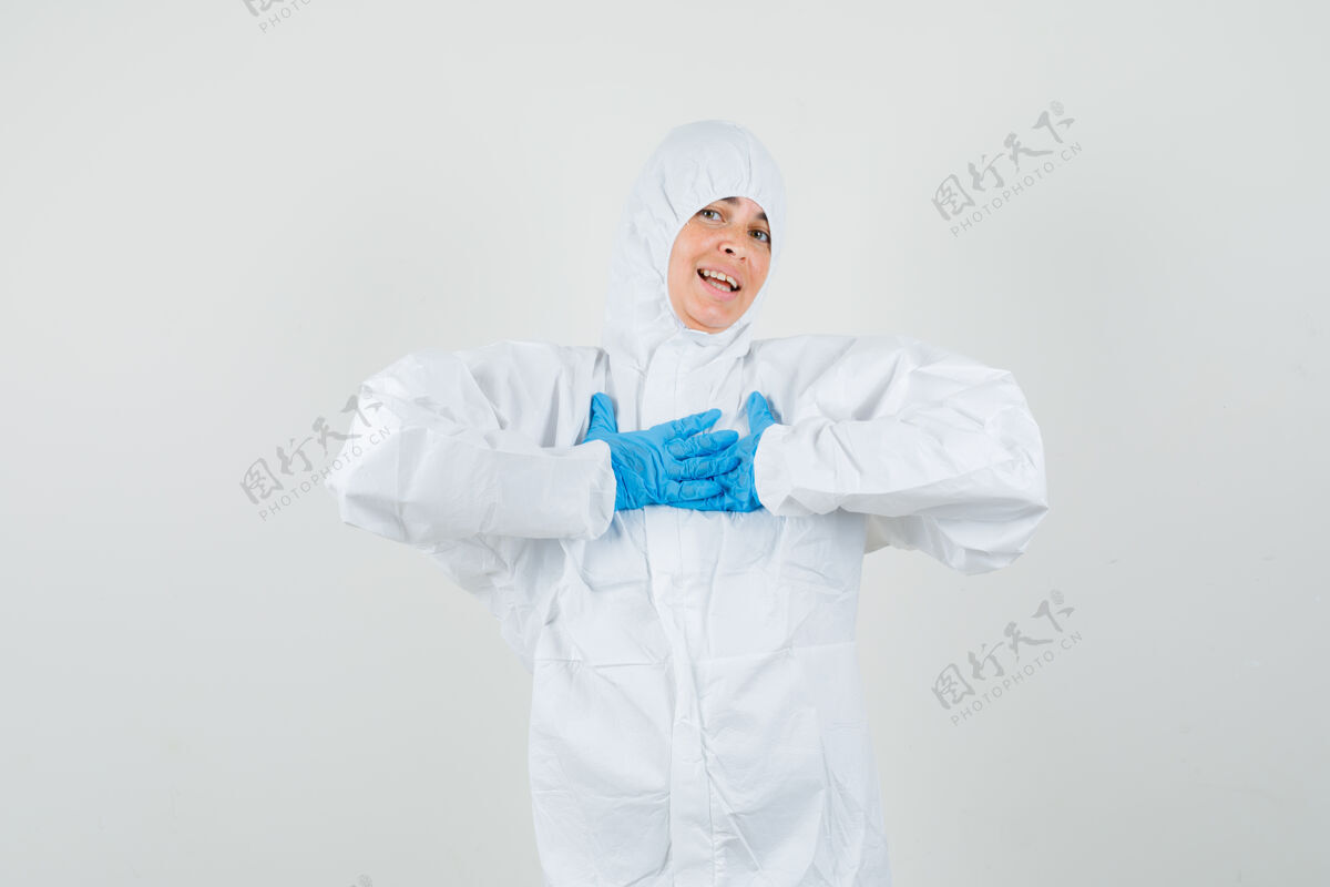 西装女医生手放在胸前 穿着防护服 戴着手套 看上去很感激医疗医生制服