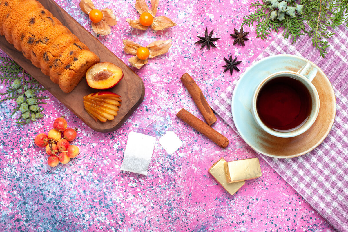 美味俯瞰美味的蛋糕 香甜可口 粉色桌上放着李子茶和甜樱桃食物顶部李子
