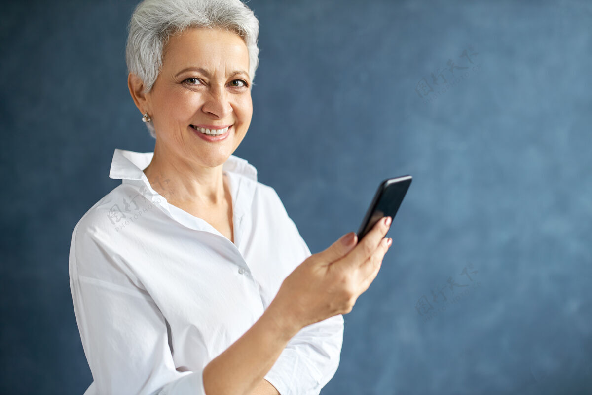 老年中年女企业家 灰色短发 手持手机 打商务电话 打短信肖像女商人成人