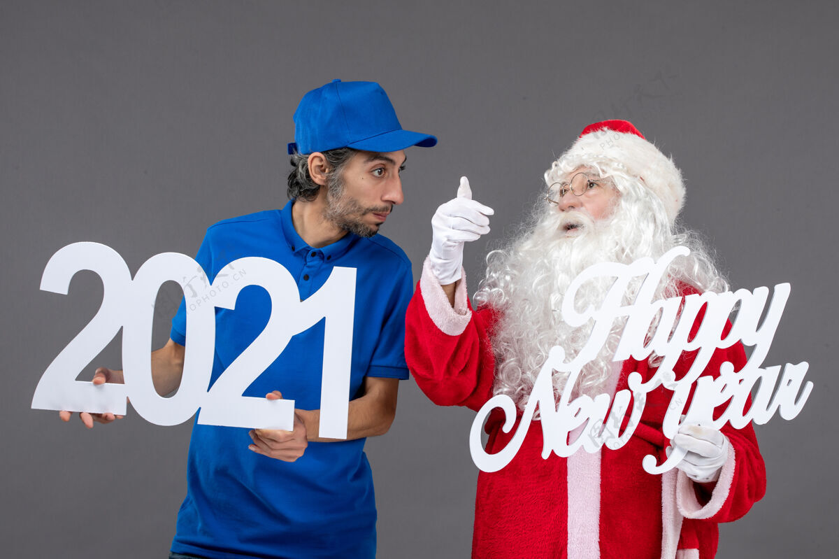 圣诞快乐圣诞老人与男信使举行和新年快乐和2021年板灰墙的正面视图快乐人们圣诞老人