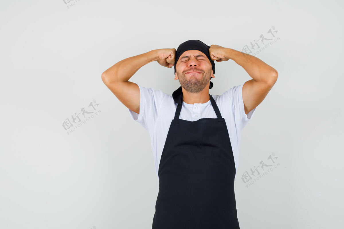 工人面包师穿着t恤拿着拳头顶着头专业工作年轻人