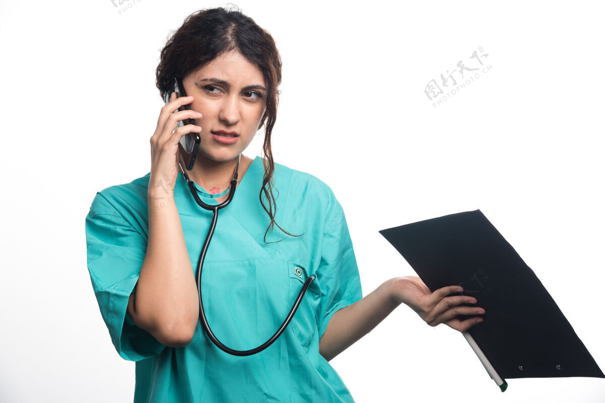 从业者年轻的女医生拿着剪贴板 在白色背景下讲着手机听诊器医生电话