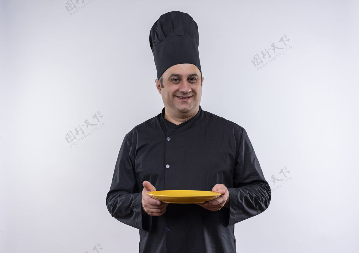 盘子笑容可掬的中年男厨师穿着厨师制服捧着盘子中年厨师厨师