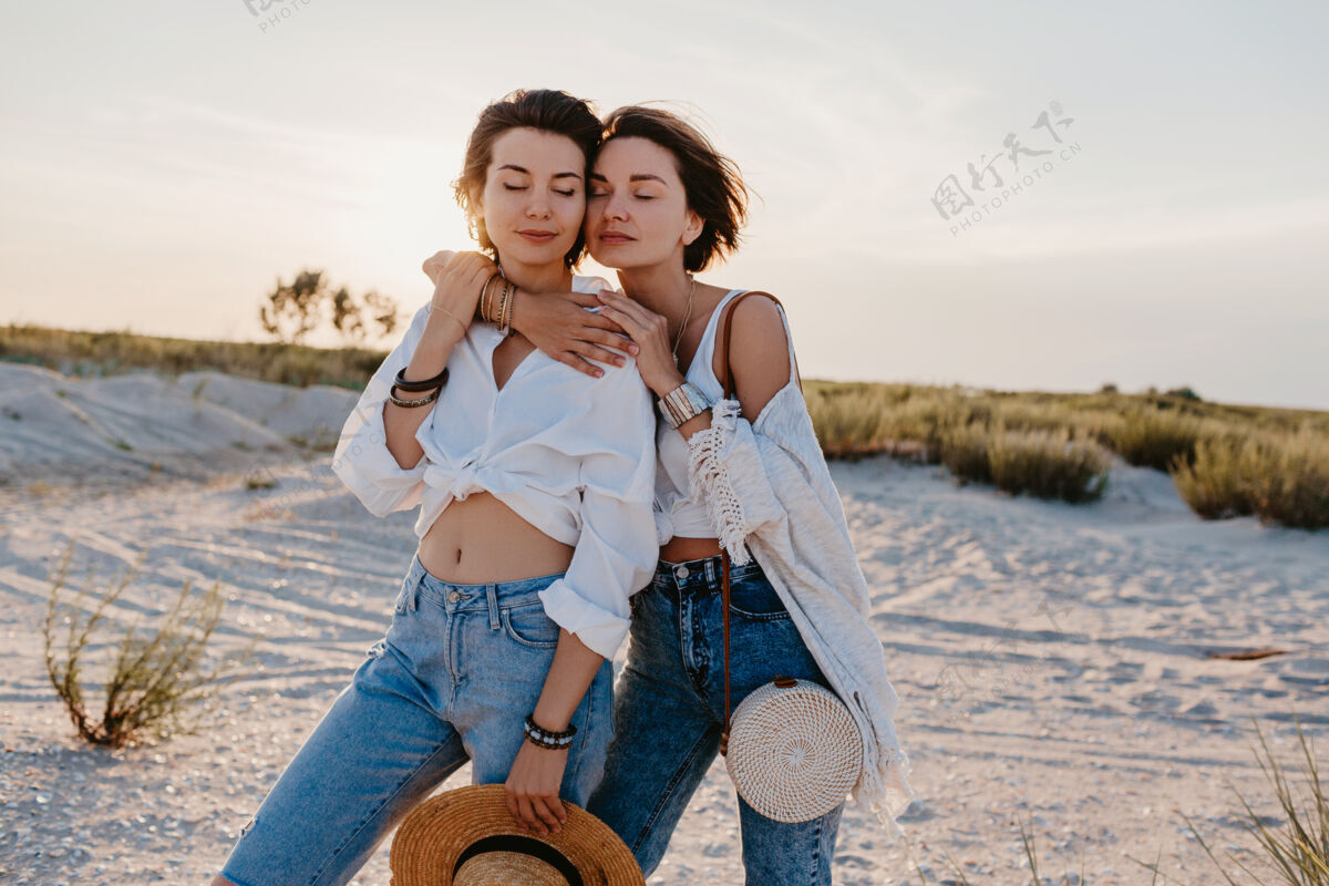 女孩酷酷的两个年轻女子在日落海滩上玩得很开心 男女同性恋的爱情浪漫情爱Lgbt女人