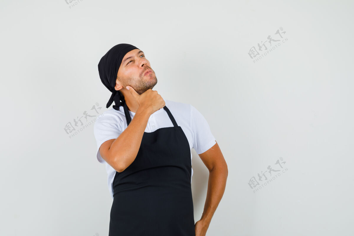 制服面包师穿着t恤 围裙抬头看着 看上去很体贴生意男人男性