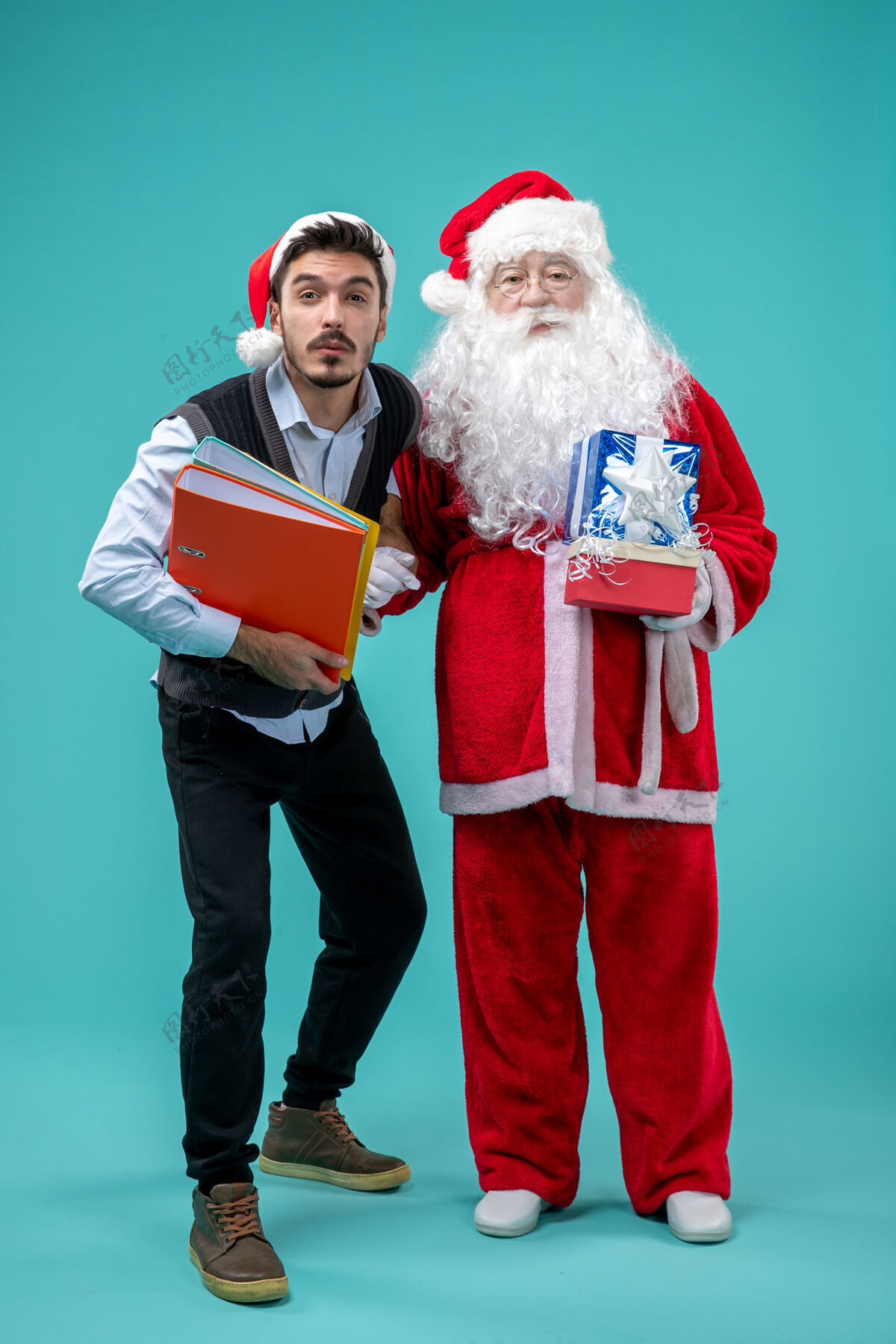 礼物圣诞老人和年轻的男性和礼物在蓝色的桌子上视图圣诞老人男人