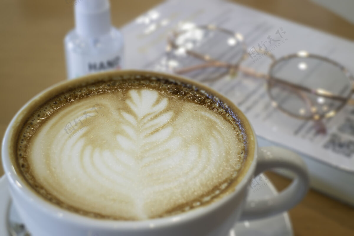 新常态咖啡杯热拿铁木桌上 股票照片早餐暗泡沫