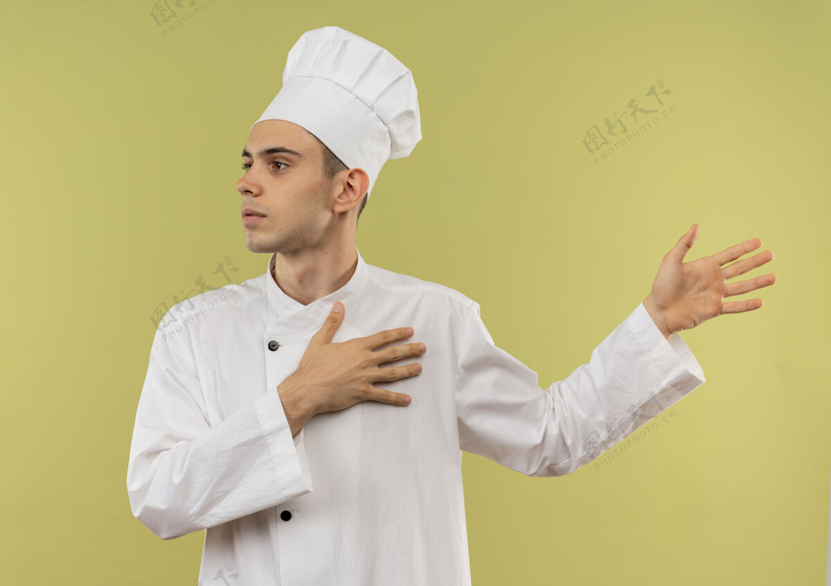 看看着旁边穿着厨师制服的年轻男厨师点着双手站在隔离的绿墙上厨师手制服