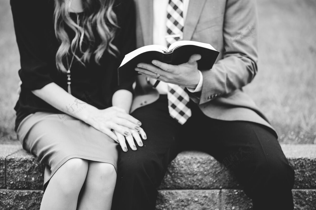 花园一对穿着正式衣服的夫妇在花园里一起看书的灰度照片信仰基督教人