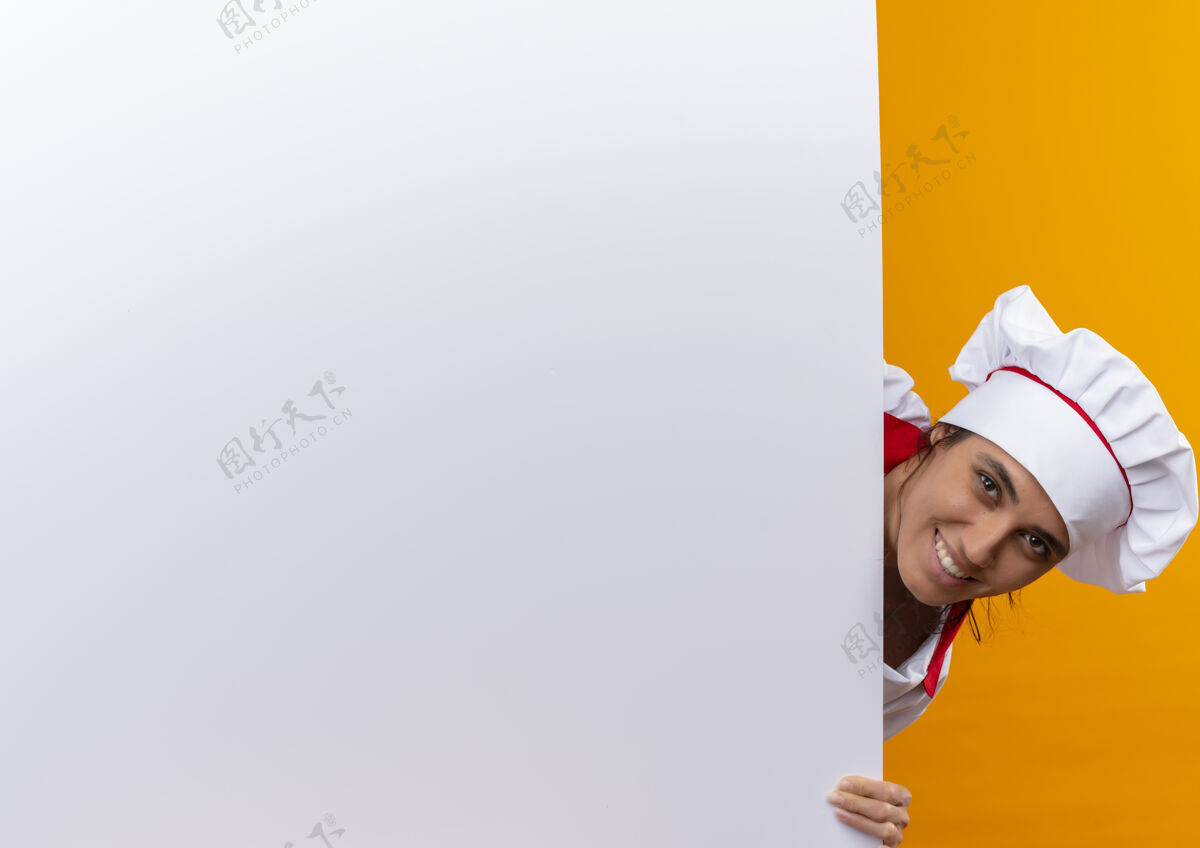 厨师面带微笑的年轻女厨师身穿厨师制服手持白墙 留有临摹空间制服戴着墙