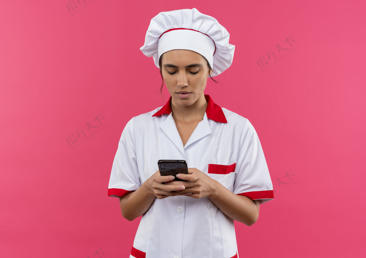 思考想年轻的女厨师穿着厨师制服拨电话号码 有复印空间电话佩戴女性
