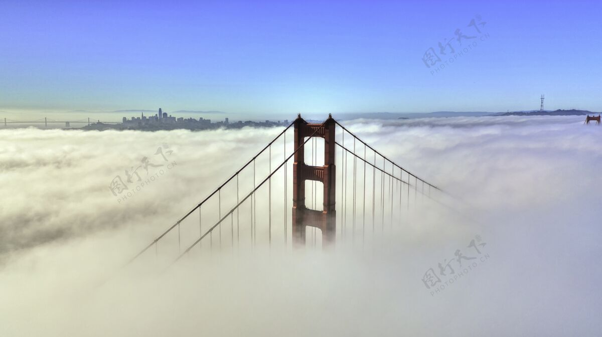 金色美丽的空中拍摄了一座被云层和蓝天包围的桥的顶部山峰环境国家