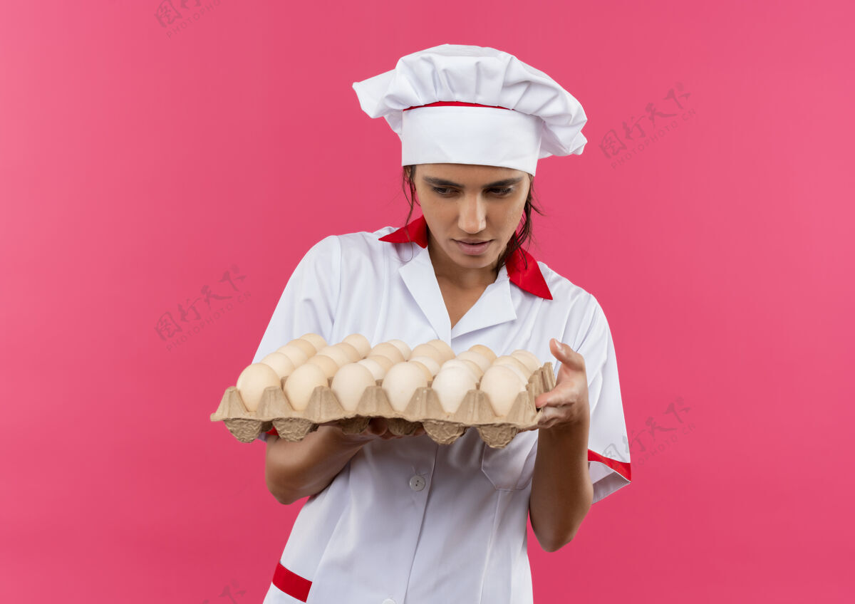持有未出炉的年轻女厨师穿着厨师制服拿着一批鸡蛋看着有复印空间批女穿着