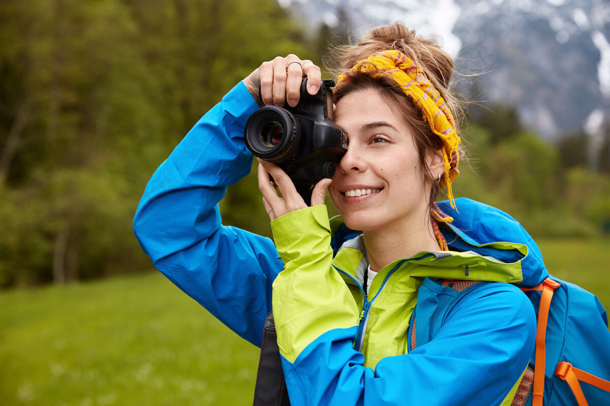 高兴快乐的年轻女游客用专业相机拍照 享受穿越绿地的乐趣水平无领女性