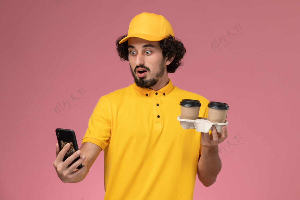 制服正面图：身穿黄色制服 披风的男性信使手拿棕色咖啡杯 粉色墙上挂着电话男粉色视野