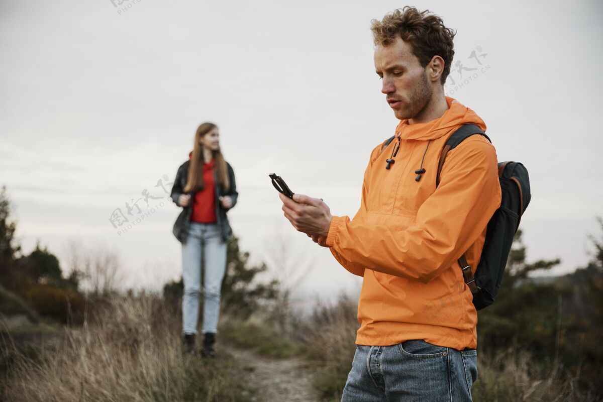 冒险男人拿着指南针和女朋友在公路上旅行水平情侣路