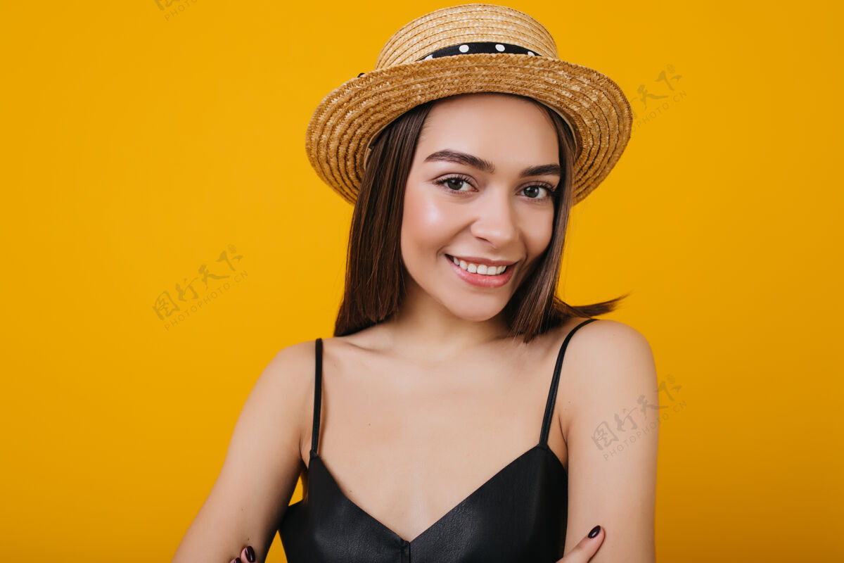高加索女人优雅的棕色眼睛的女孩戴草帽的特写镜头穿着黑色背心的可爱的浅棕色女人的室内照片时尚成人人