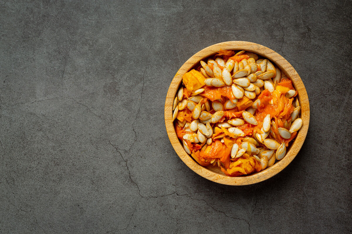 谷物南瓜子放在木碗里 放在深色的地板上蛋白质配料作物