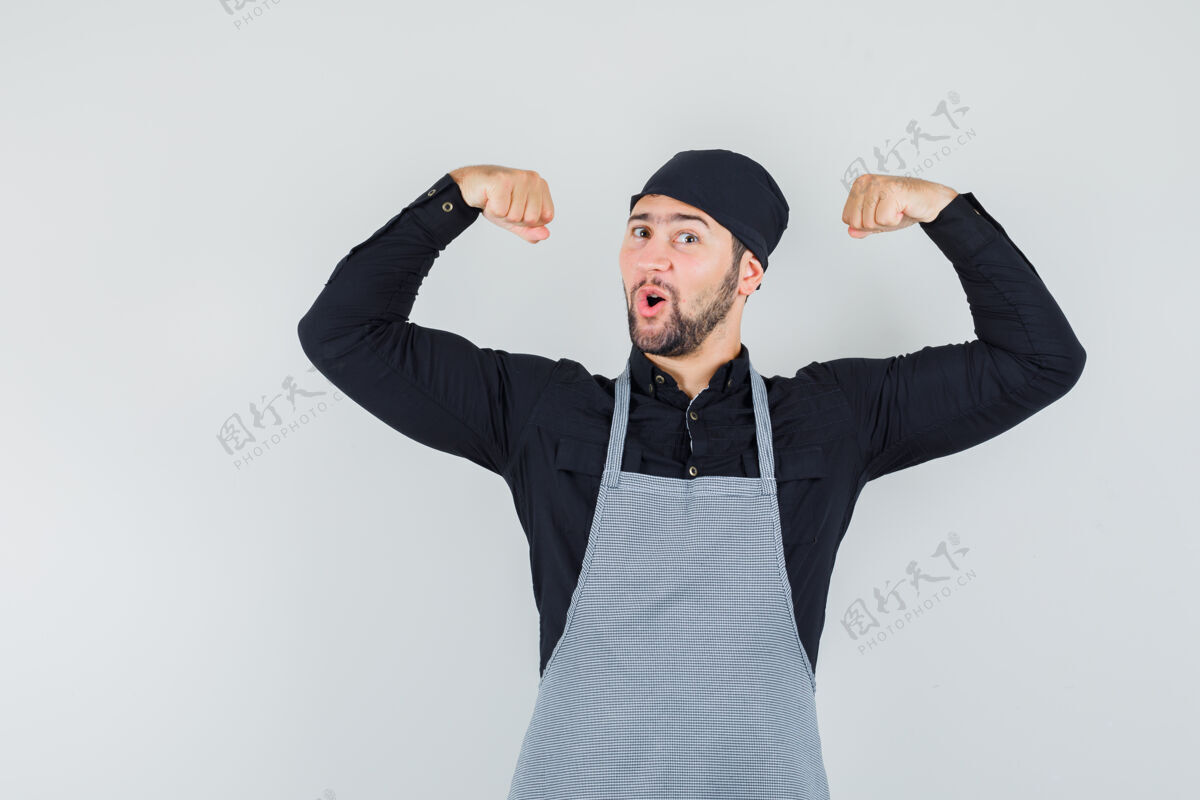 食物男厨师穿着衬衫 围裙展示肌肉 看起来很有力量 正面图肖像职业餐厅
