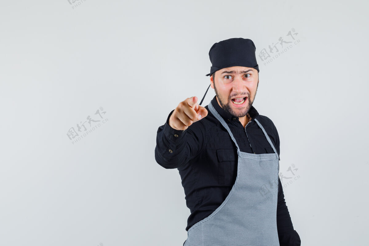 膳食男厨师穿着衬衫 围裙指着摄像机 神情紧张 正对着镜头食物围裙年轻人
