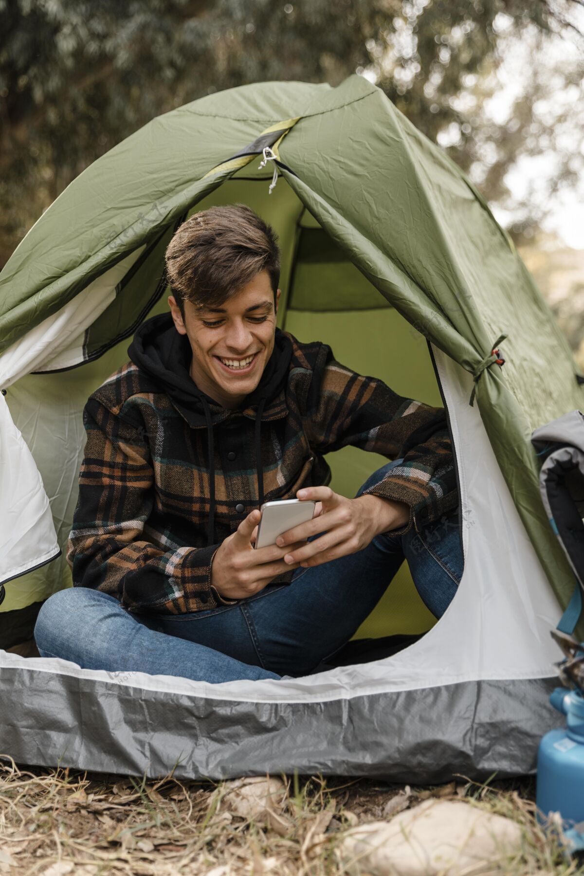 木材快乐的野营者在森林里用手机旅游户外旅行
