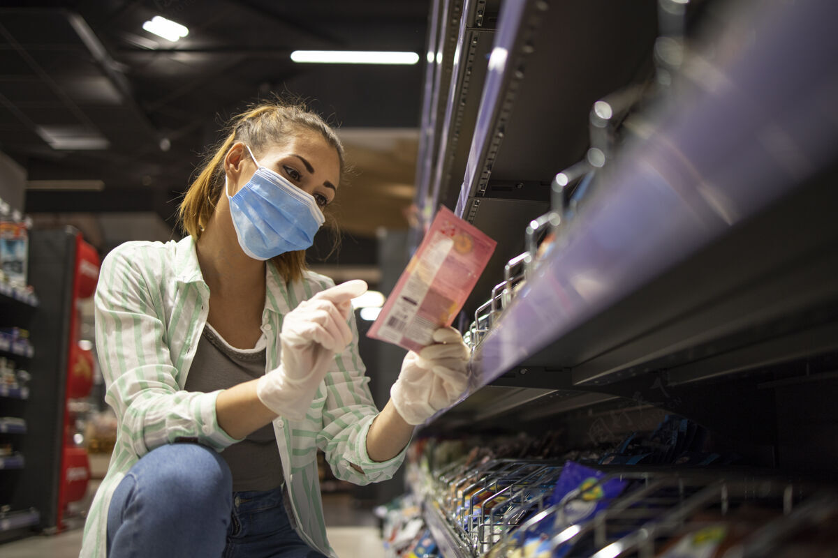 医疗保健戴着口罩和手套在超市买食物的女人疾病防护商店成人