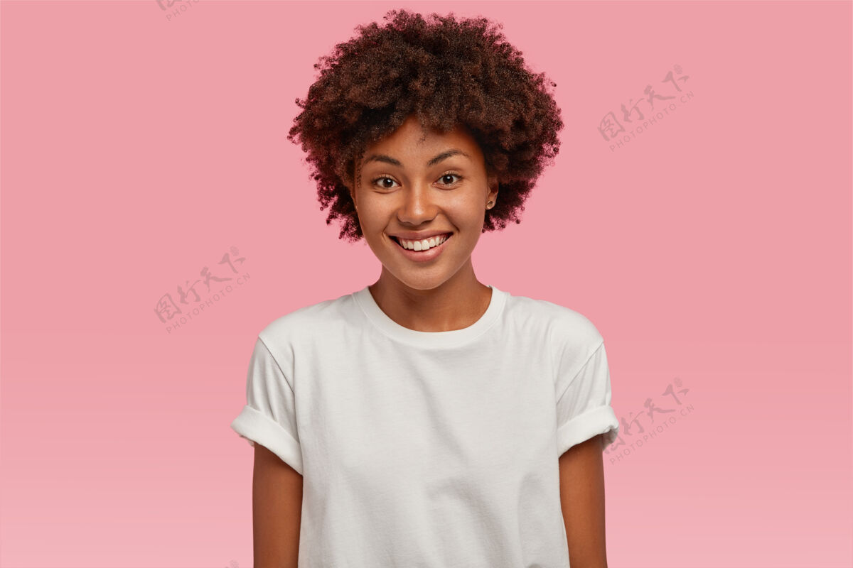 看迷人的非洲裔美国年轻女子 带着牙齿般温柔的微笑 露出洁白的牙齿 穿着休闲的模拟t恤思考种族高兴