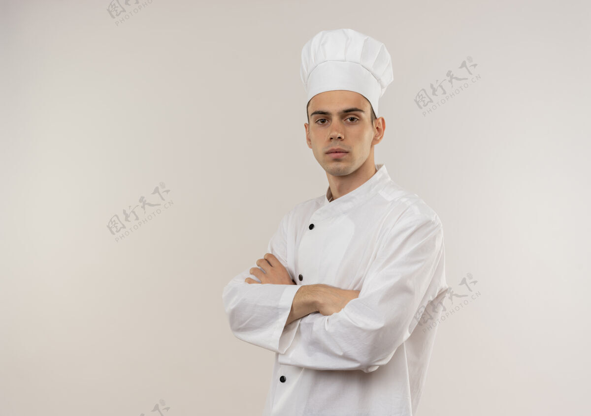 手自信的年轻男厨师穿着厨师制服 双手交叉放在隔离的白色墙壁上 留有复制空间年轻看起来自信