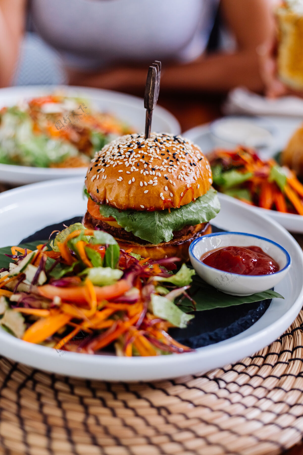 沙拉多汁汉堡和新鲜蔬菜放在咖啡馆的桌子上小吃美味美味