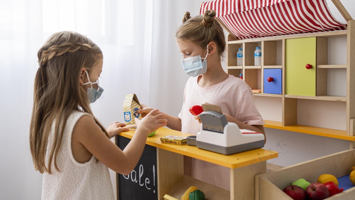 选择孩子们戴着医用口罩在室内玩耍非二元规范面具