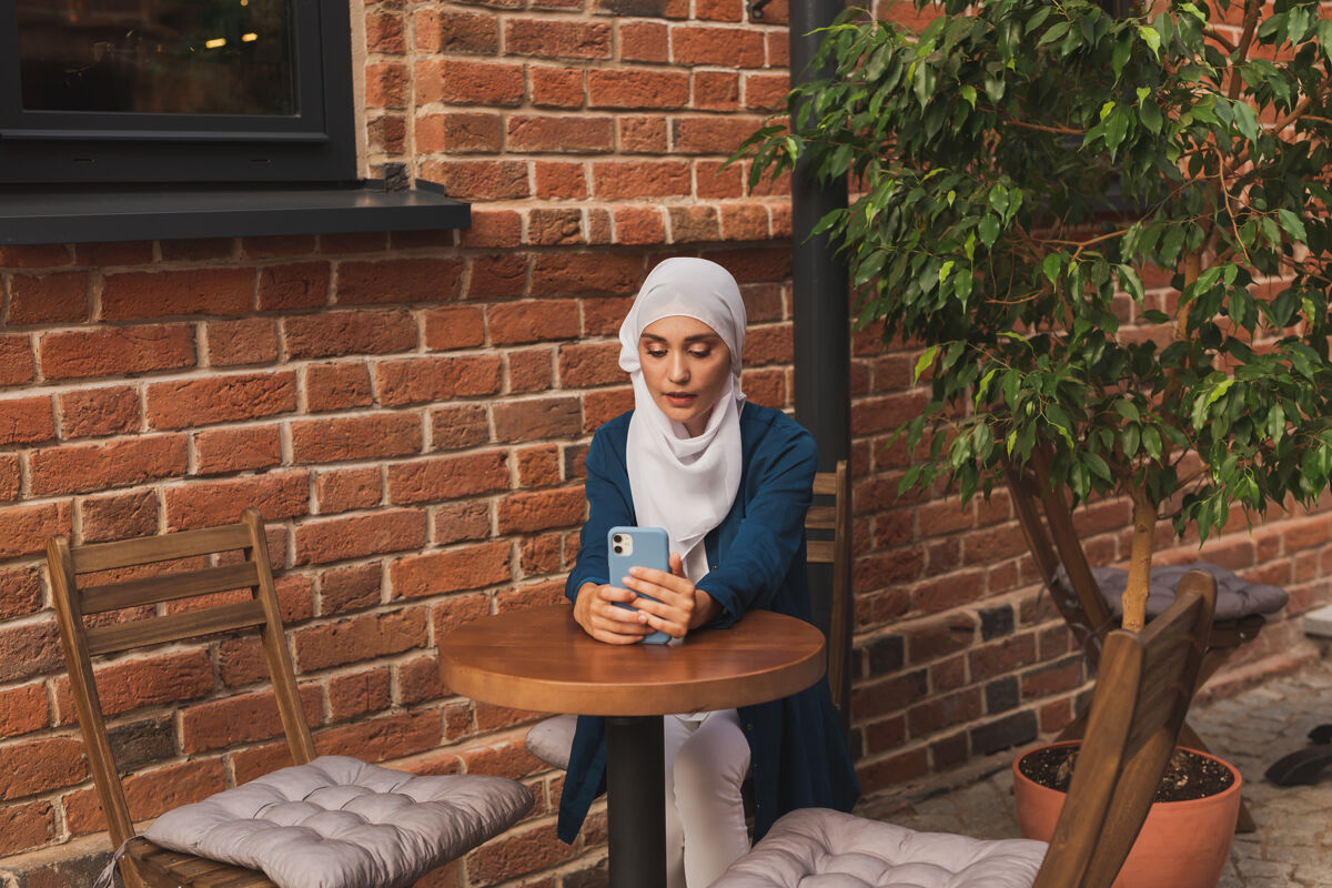 室内快乐的穆斯林妇女在城市里用智能手机进行视频通话亚洲人年轻视频通话