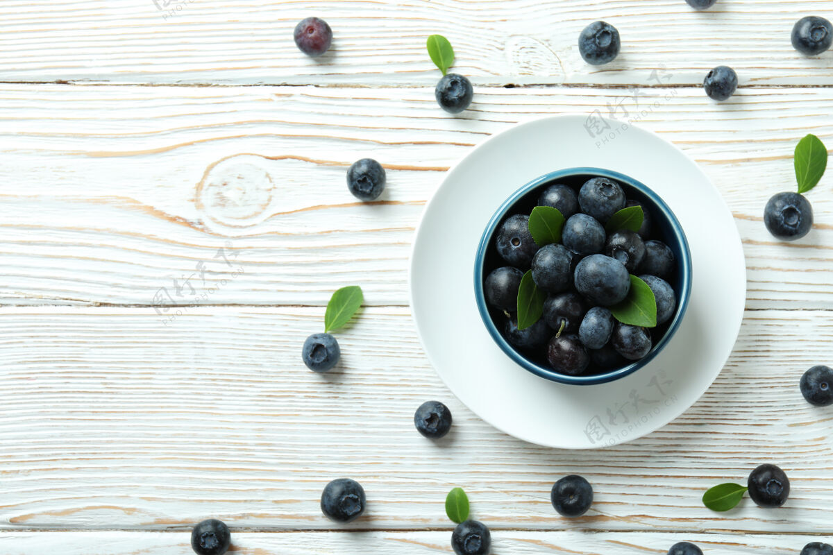 黑莓新鲜的浆果概念和蓝莓放在白色的木桌上顶部碗甜点